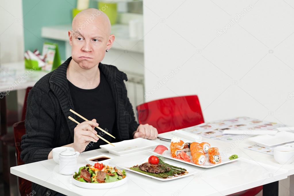 Man eats sushi. 