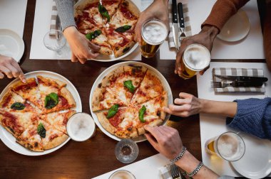Tanınmayacak kadar çok ırklı bir grup insanın ellerinin bir dilim lezzetli İtalyan pizzasını ve bir bardak birayı kaptığı en iyi manzara masası..