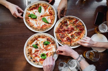 Masada en güzel üç İtalyan pizzası var. Tanınmayan insanların elleri bir dilim alıyor..