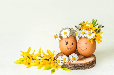 Yumurtalı Paskalya kompozisyonu, arka planda sarı çiçekli dallar..