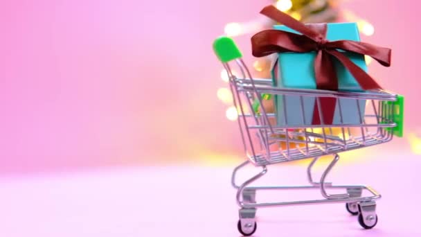 4k present box with a ribbon in a shopping trolley cart. Concept - buying a gift ,online and sale. — Stockvideo