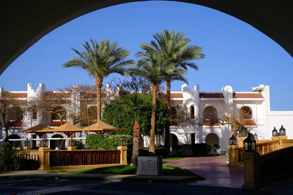 EGYPT Sharm el Sheikh. The tourists are on vacation at luxury hotel Savoy hotel main building surrounded by palm trees.Sunny day, blue sky — стокове фото