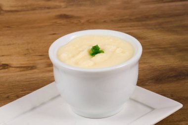 mashed potatoes in white bowl on wooden background