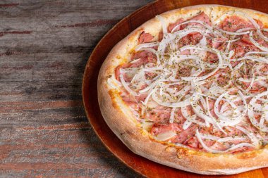 Ahşap arka planda pepperoni pizza. Pizza de calabresa adında Brezilya pizzası..