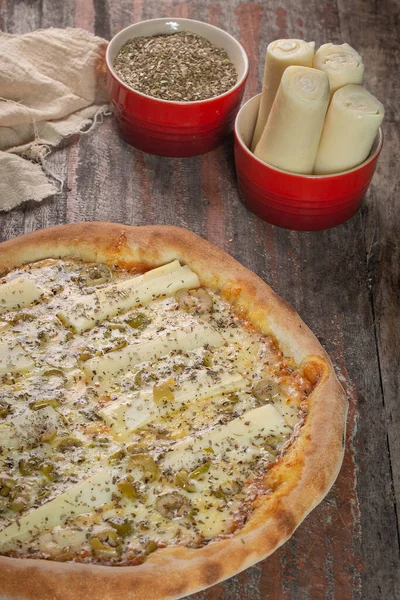 Palmiye pizzasının nefis kalbi ahşap masada.