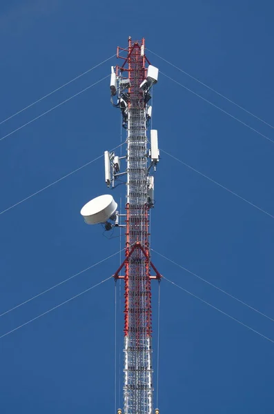Temiz mavi gökyüzü arka planında internet kuleleri ve iletim ekipmanları