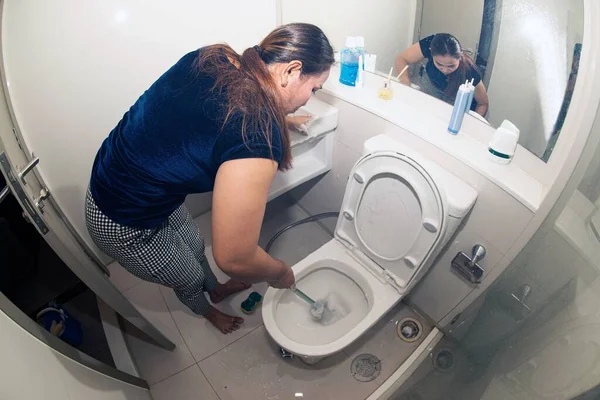 一个亚洲女人正在洗澡间里的马桶 — 图库照片