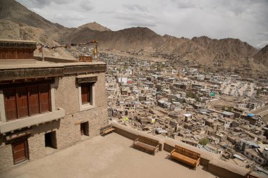 Köşedeki üst manzara ve gri taşın detayları ve ahşap kapılar ve pencereler, balkonlarda Ladakh, Hindistan 'daki Leh Sarayı' nın parmaklıkları yok.. 