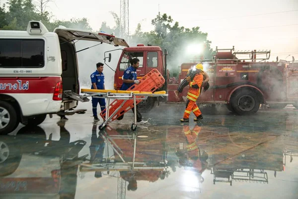 PhICHIT, THAILAND - 29 AĞUSTOS 2020: Kimliği belirsiz itfaiyeciler, yangında acı çeken ve bayılan adama yardım etmek üzere eğitildi. Bir sürü yanık ve duman bırak..