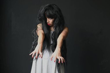 Korkunç Hayalet Kadın 'da Cadılar Bayramın kutlu olsun. Asyalı hayalet ya da zombi korkusunun tüyleri vardır. Yüzü ve gözleri kaplıdır. Terk edilmiş evde, karanlık odada kollarına uzanır.. 