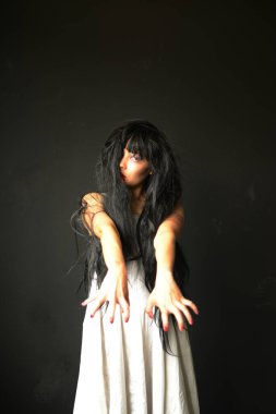 Korkunç Hayalet Kadın 'da Cadılar Bayramın kutlu olsun. Asyalı hayalet ya da zombi korkusunun tüyleri vardır. Yüzü ve gözleri kaplıdır. Terk edilmiş evde, karanlık odada kollarına uzanır.. 