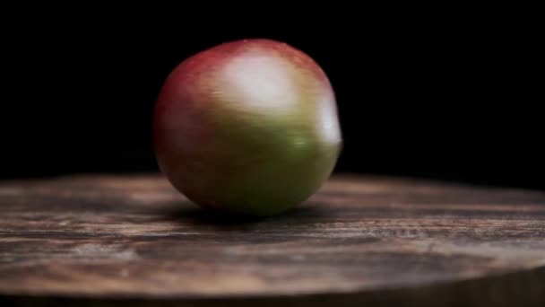 エキゾチックなマンゴーフルーツがテーブルの上に回っています スローモーション 暗い背景だ 熟した果実 マンゴーはおいしくて健康的な果物です — ストック動画