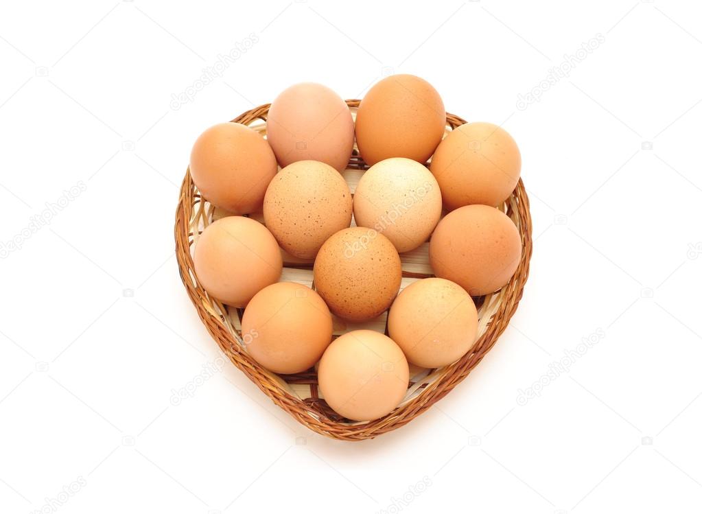 Dozen eggs in a wicker basket on a white background