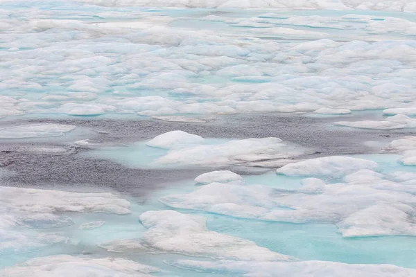 Abstract landscape with pools of aqua water in ice floes of high arctic.