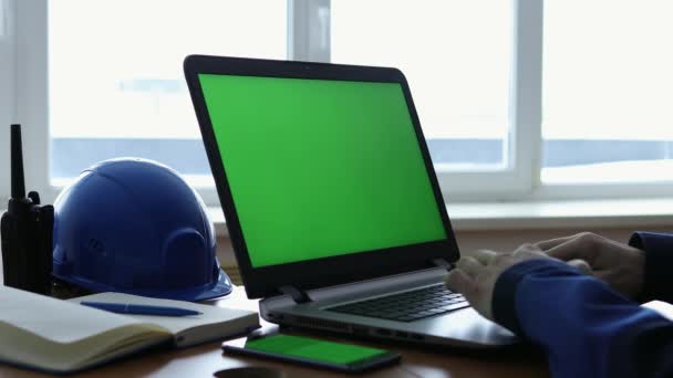Αρσενικός μηχανικός που χρησιμοποιεί φορητό υπολογιστή με πράσινη οθόνη στο εσωτερικό του γραφείου. — Αρχείο Βίντεο