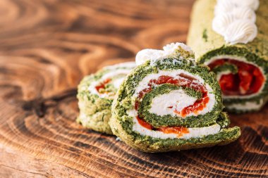 Tahta masada ıspanaklı ve kırmızı balıklı dilimlenmiş rulo..