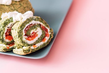 Dilimlenmiş rulo ıspanak ve pembe arka planda kırmızı balık..