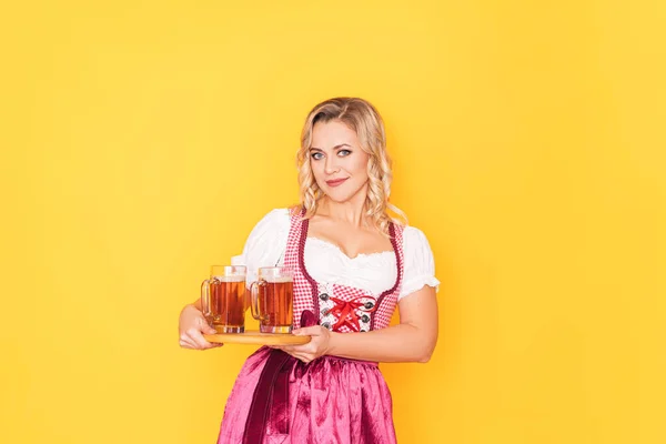 Mujer en vestido alemán festivo sosteniendo tazas de cerveza —  Fotos de Stock