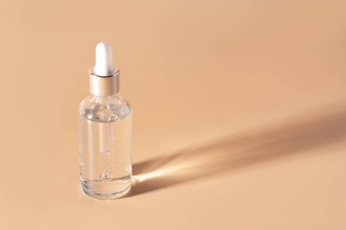 Bej arka planda serumla dolu pipetli cam şişe..