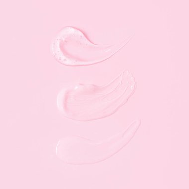 Pembe arka planda üç şeffaf serum lekesi.