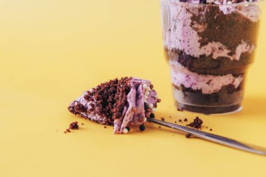 Bardakta puf kek, sarı arka planda kaşık..