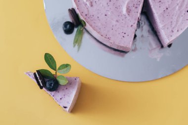 Sarı arka planda dilimlenmiş mor peynirli kek. 2022 Yılı Rengi