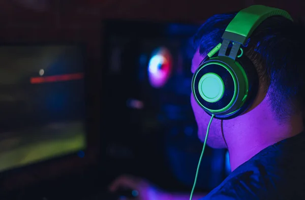 男はネオン照明の下でコンピュータクラブでビデオゲームをプレイ — ストック写真
