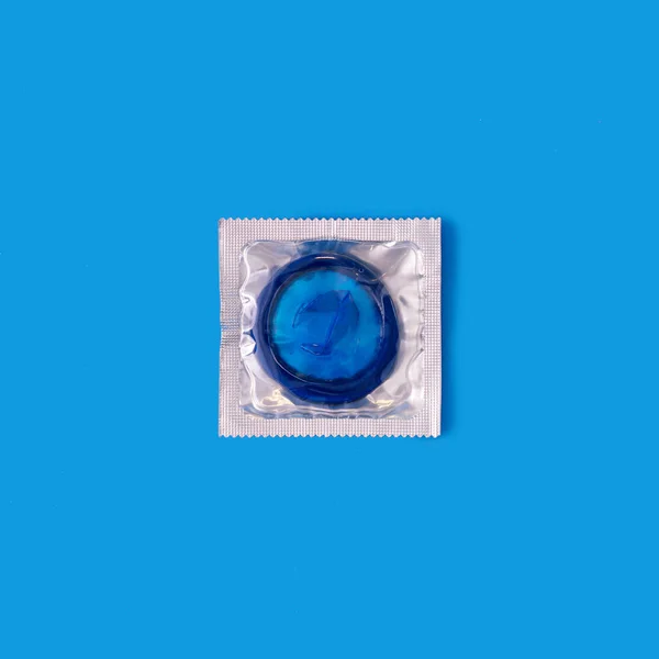 Preservativo azul em pacote transparente contra fundo azul — Fotografia de Stock