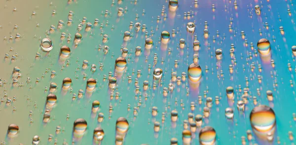 Σταγόνες νερού σε γυάλινη επιφάνεια ουράνιο τόξο — Φωτογραφία Αρχείου