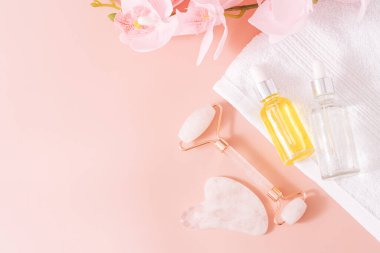 Pembe arka planda cam şişeler ve el masajcıları.