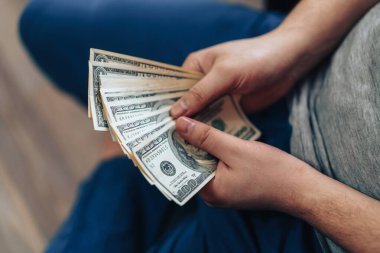 Elinde yüz dolarlık banknotlar tutan adam