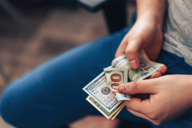 Adam elinde 100 dolarlık banknotlar sayıyor.