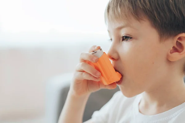Menino inala a medicina através de um inalador de asma — Fotografia de Stock