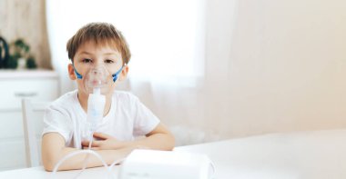 Yüzünde maske olan küçük çocuk ilaç soluyor.