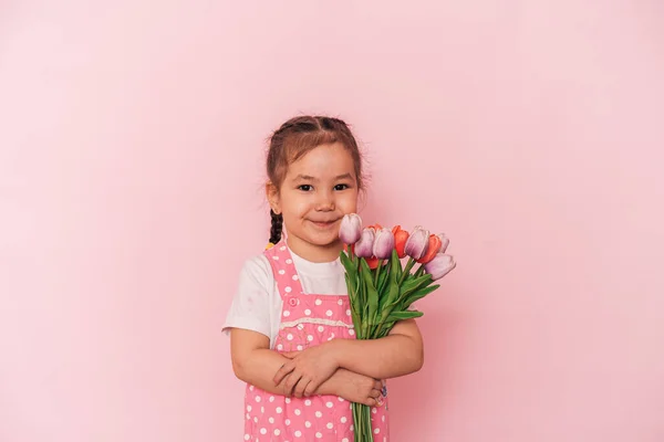 Маленькая азиатка с букетом цветов на розовом фоне, счастливого дня матери — стоковое фото
