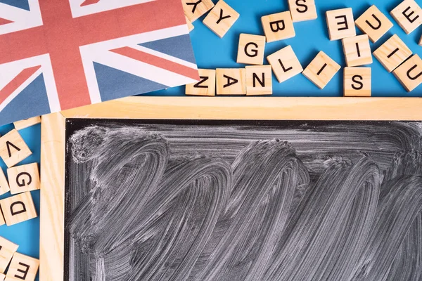 Karton s bílými pruhy vedle písmen a britskou vlajkou — Stock fotografie