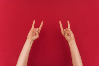 Kadın elleri kırmızı arka planda rock 'n roll sembolü gösteriyor