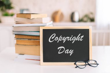 Telif hakkı günü yazılı tebeşir tahtası bir yığın kitabın yanında duruyor.