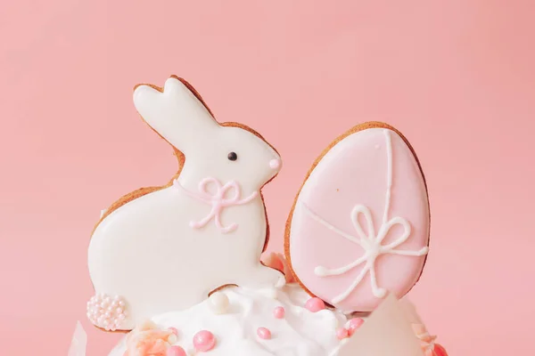 Pastanın üstünde pembe arka planda tavşan ve yumurta kurabiyeleri. — Stok fotoğraf