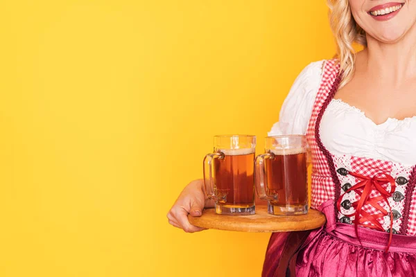 İki kupa biralı, şenlikli Alman elbisesi giymiş bir kadın. — Stok fotoğraf