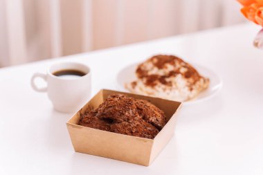 İki kek ve beyaz masa üzerinde bir fincan kahve.