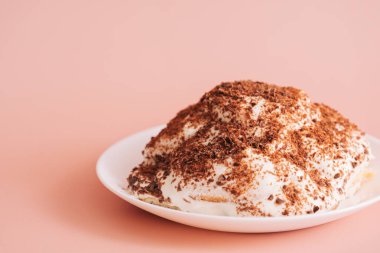 Pembe arka planda beyaz tabakta kaplumbağa keki