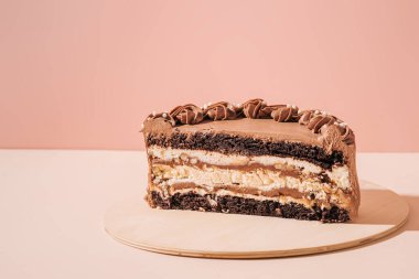 Pembe arka planda yarım çikolatalı pasta