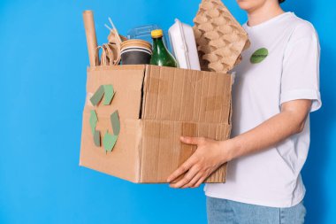 Gönüllü kız çöp kutusunu geri dönüşüm için tutuyor..