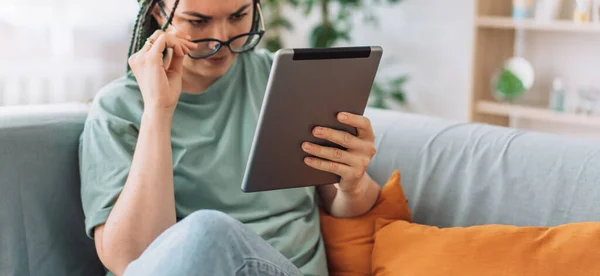 Girl with poor eyesight reads book on tablet.