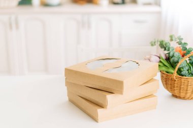 Üç kutu sıcak turta beyaz masada duruyor..