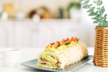 Sepetin yanındaki beyaz masada çilekli kremalı pasta..