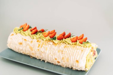 Mavi tabakta çilekli kremalı pasta..