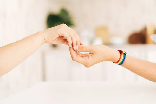 Two Female Hands Hold Each Other Lgbt Bracelet — ストック写真