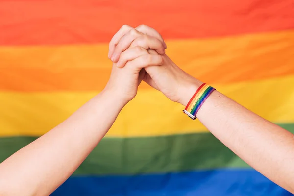 Two Female Hands Hold Each Other Rainbow Background — Stockfoto